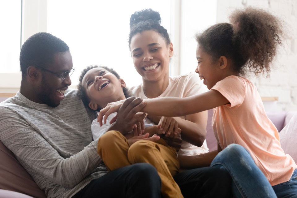 happy family laughing on the couch